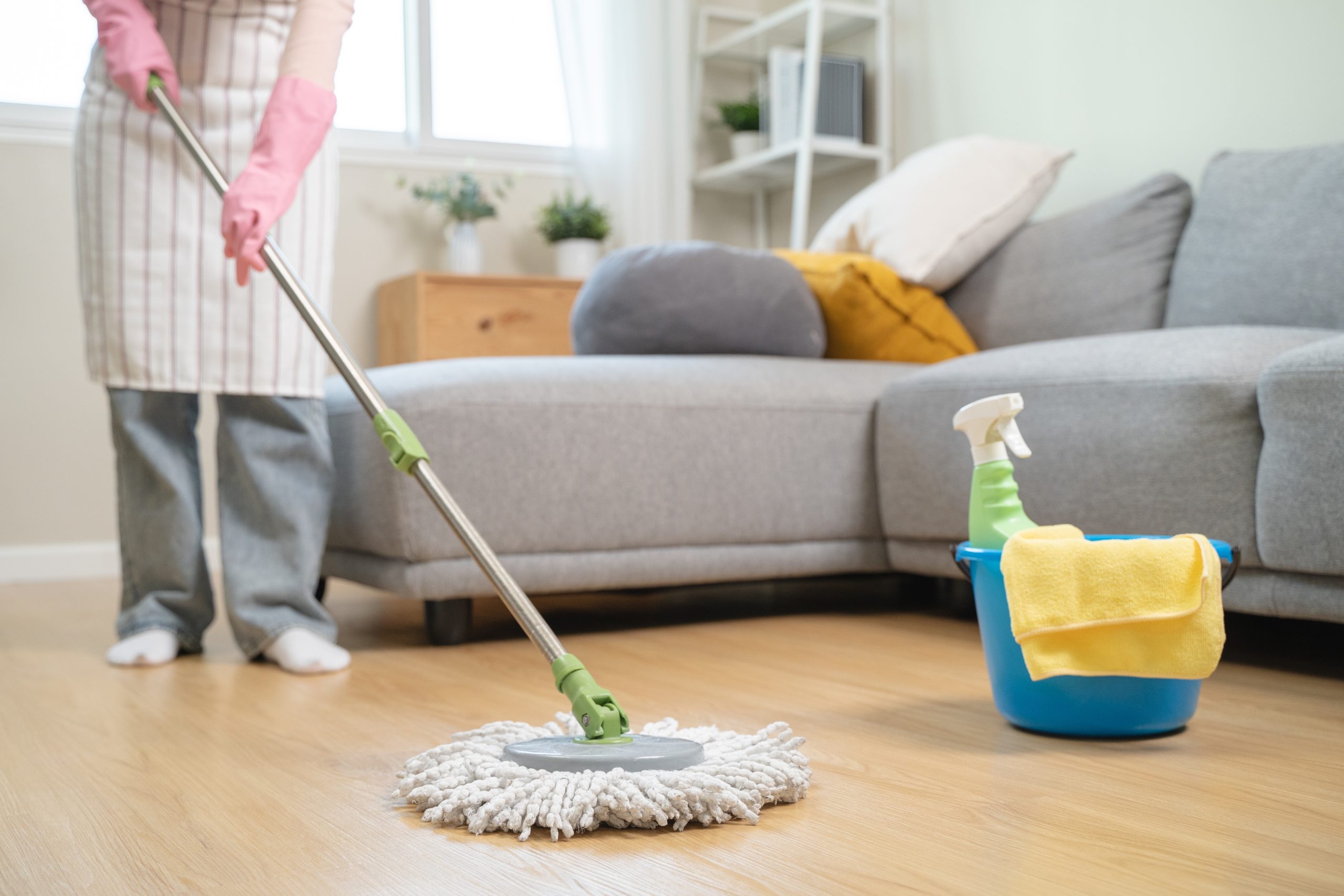 Homeowner mopping a newly finished oak hardwood floor after Wood Floor Sanding in a South Woodford living room.
