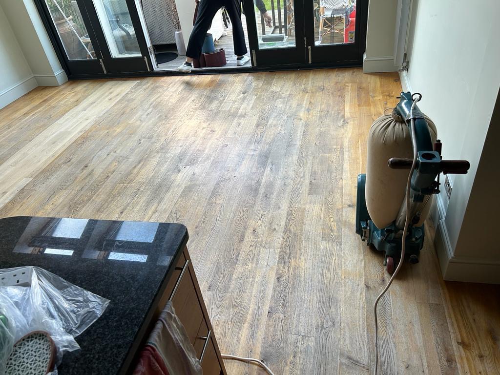 Wood Floor Sanding in Southwoodford on an engineered oak plank kitchen-diner floor, with professional sanding machine preparing boards for refinishing.