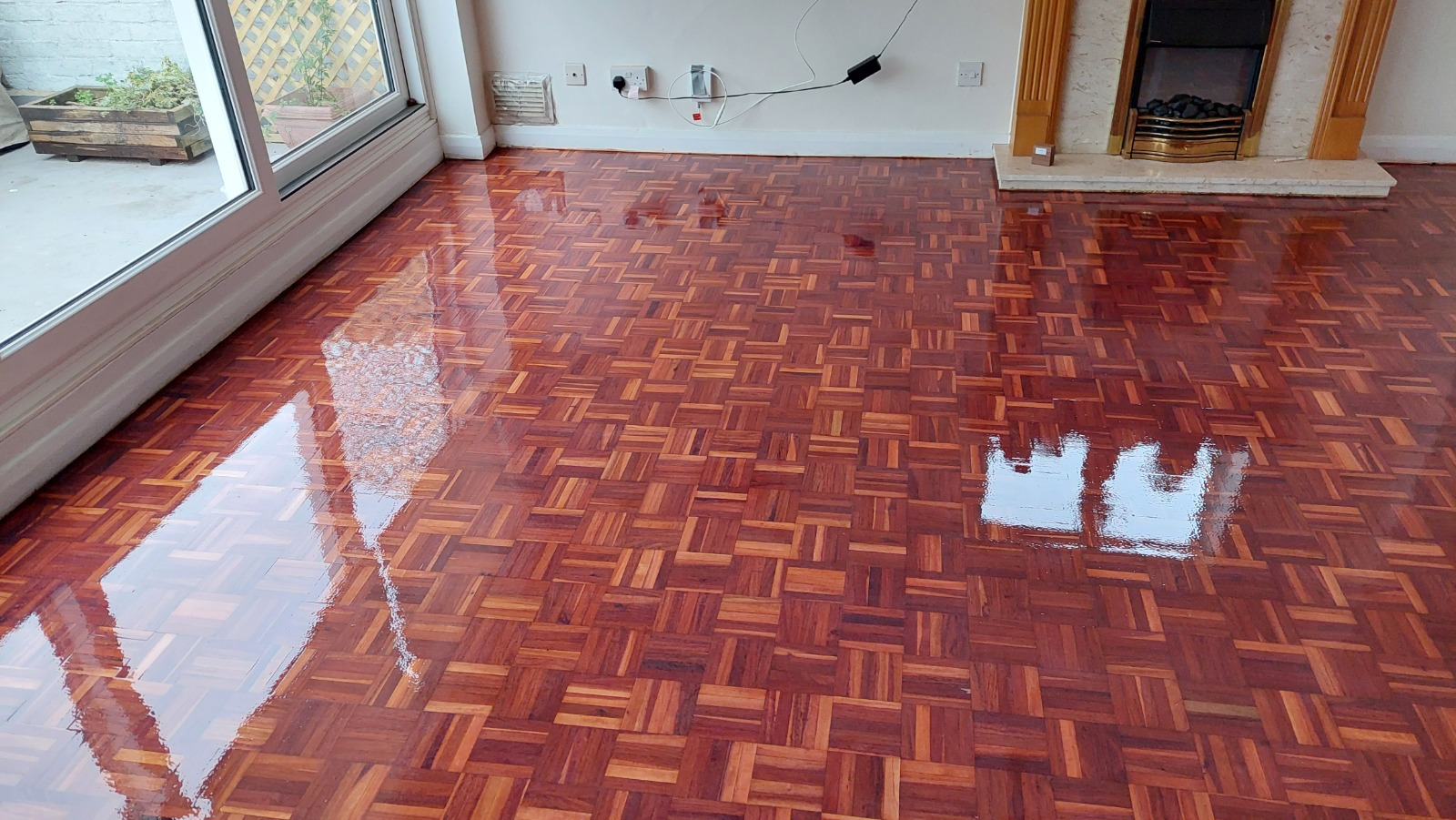Wood Floor Sanding in Southwoodford revealing a high-gloss hardwood mosaic parquet wood block living room floor, freshly sealed and shining after refinishing.